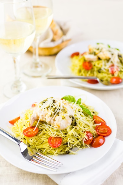 Pasta casera de cabello de ángel con salsa pesto, tomates cherry asados y pollo a la plancha.