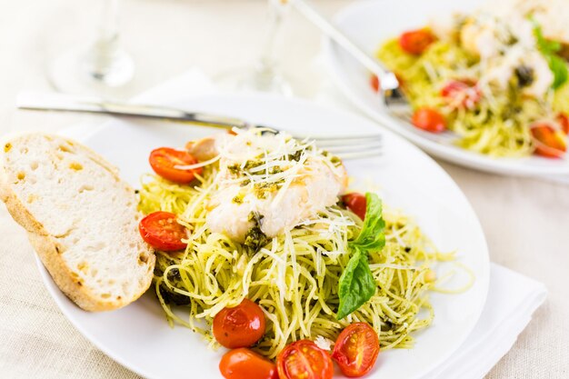 Pasta casera de cabello de ángel con salsa pesto, tomates cherry asados y pollo a la plancha.