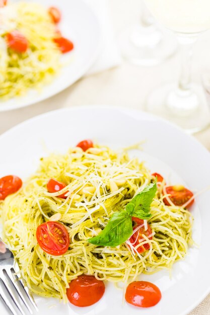 Pasta casera de cabello de ángel con salsa pesto y tomates cherry asados.