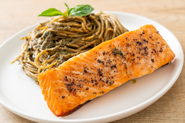 Pasta casera con espaguetis al pesto con salmón a la parrilla - estilo de comida italiana