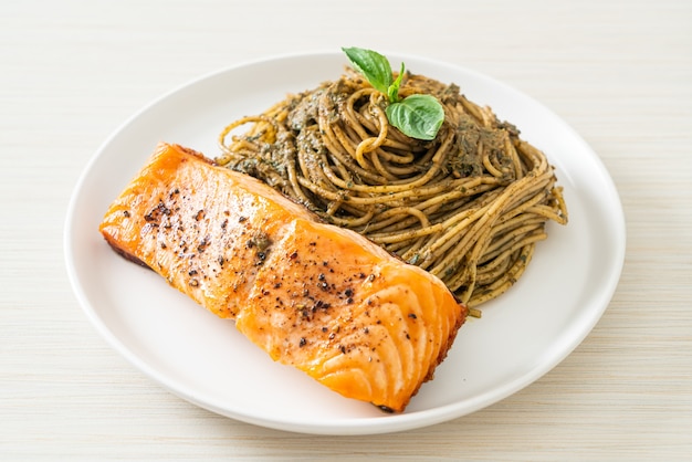 Pasta casera con espaguetis al pesto con salmón a la parrilla - estilo de comida italiana