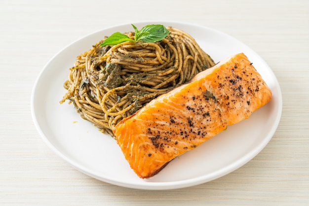 Pasta casera con espaguetis al pesto con salmón a la parrilla - estilo de comida italiana