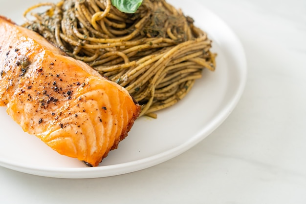 Pasta casera con espaguetis al pesto con salmón a la parrilla - estilo de comida italiana