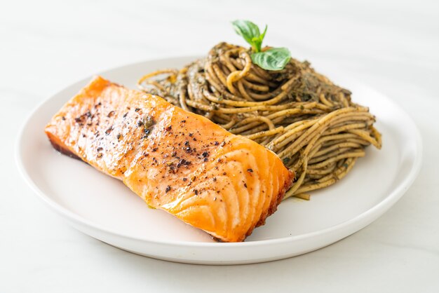 Pasta casera con espaguetis al pesto con salmón a la parrilla - estilo de comida italiana