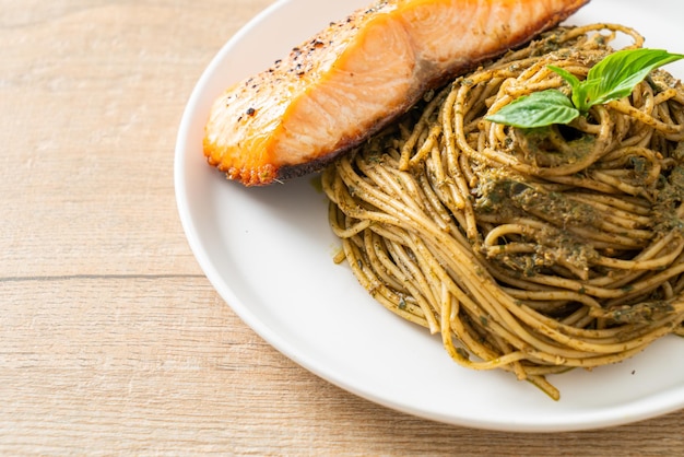 Pasta casera con espaguetis al pesto con salmón a la parrilla - estilo de comida italiana