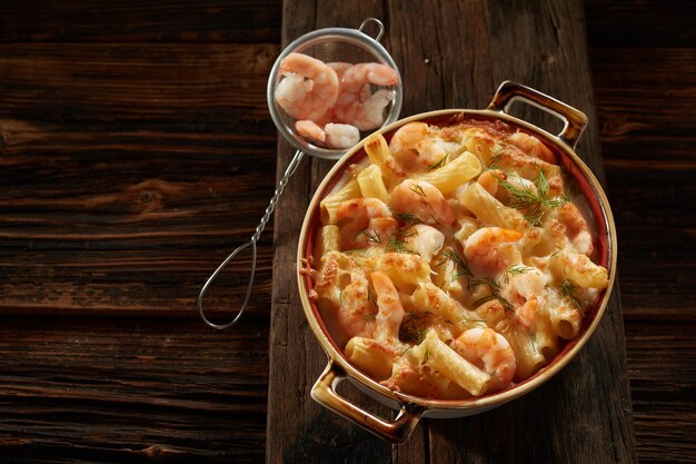 Pasta casera con gambas y salsa servida en mesa de madera