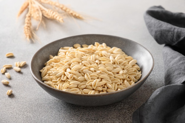 Pasta Cavatelli en un tazón sobre fondo gris