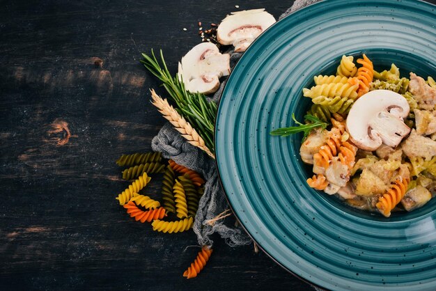 Pasta con champiñones y pollo Sobre un fondo de madera Cocina italiana Vista superior Espacio de copia