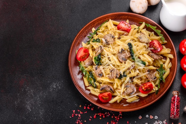 Pasta con champiñones, queso, espinacas, rukkola y tomates cherry. Plato italiano, cultura mediterránea