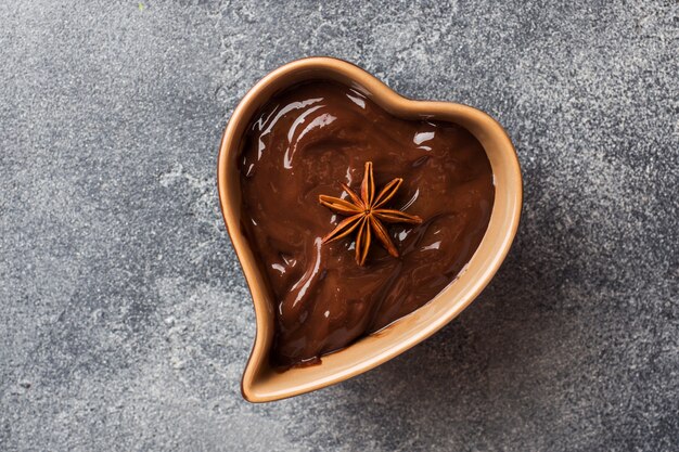 Pasta de chocolate con canela y anís. Fondue de chocolate sobre una mesa de hormigón oscuro. copia espacio