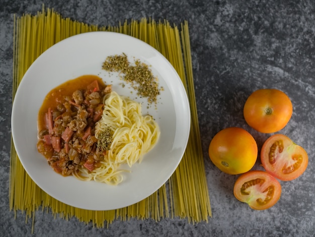 Foto pasta cocida madura espagueti salsa de tomate orégano en plato blanco