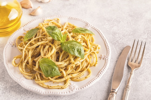 Pasta cocida con salsa pesto y hojas de albahaca