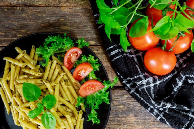 Pasta cocida con tomate, albahaca y verduras frescas.