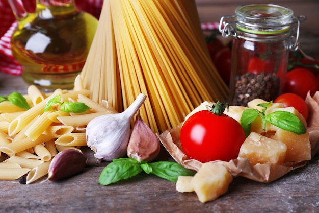 Pasta com tomates cereja e outros ingredientes em fundo de madeira