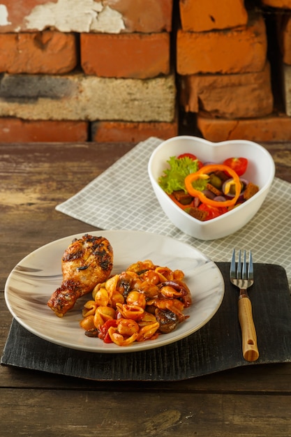 Pasta de conchas en tomate con muslo de pollo al horno a la parrilla