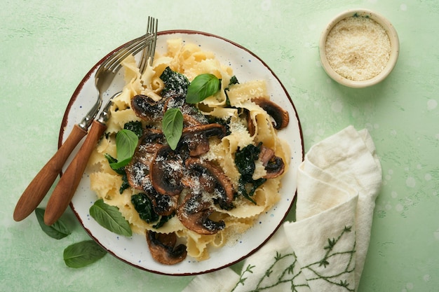 Pasta cremosa Alfredo pasta italiana fettuccini com cogumelos carne de frango espinafre manjericão e molho de creme em pedra verde ou fundo de concreto cozinha tradicional italiana espaço de cópia plana