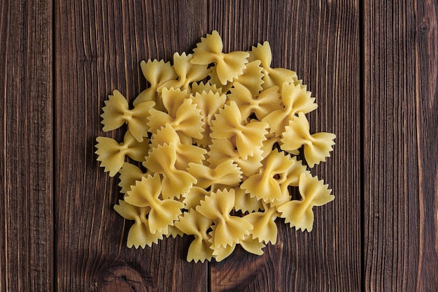 Pasta cruda farfalle sobre fondo de madera