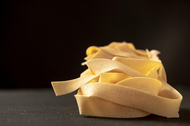 Pasta cruda pappardelle closeup pasta italiana tradicional