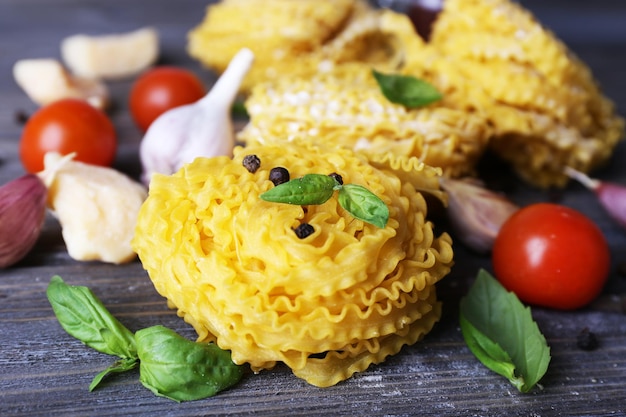 Pasta cruda con queso y verduras sobre fondo de madera