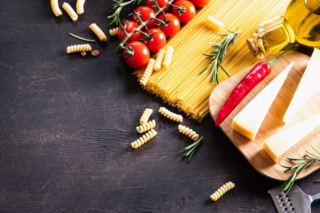 Pasta cruda sobre fondo de madera Vista superior Pasta cruda con ingredientes para cocinar Concepto de comida Comida italiana