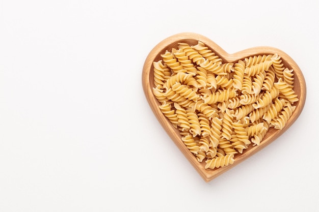 Pasta en un cuenco de madera en forma de corazón