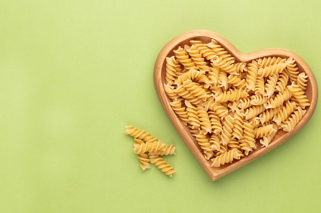 Pasta en un cuenco de madera en forma de corazón