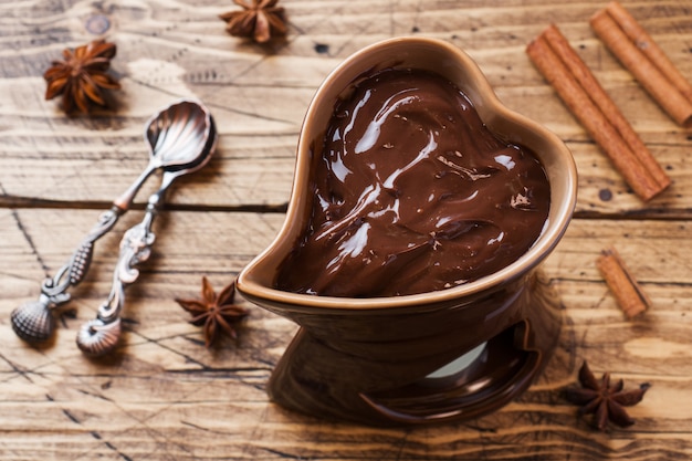 Pasta de chocolate com canela e anis. fondue com chocolate em uma mesa de madeira.