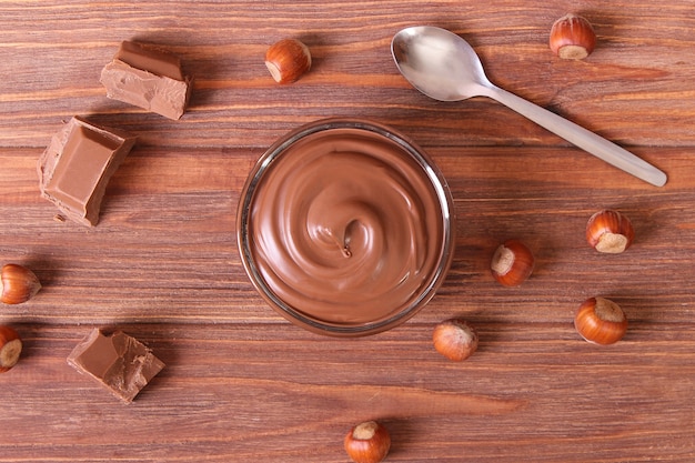 Foto pasta de chocolate em uma jarra de vidro em um fundo colorido