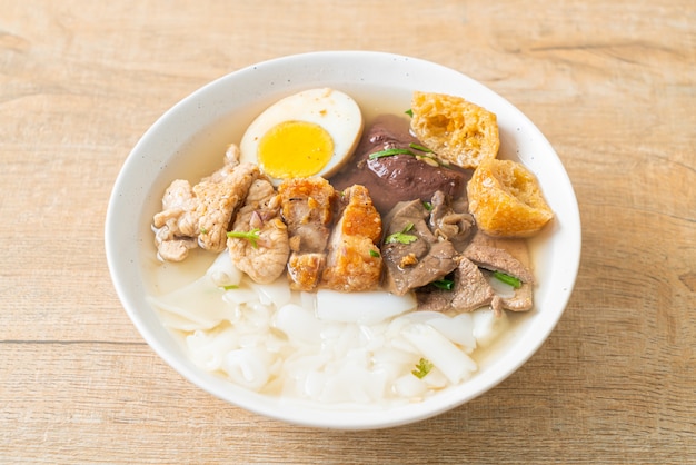 Pasta de farinha de arroz ou quadrado de macarrão chinês cozido com carne de porco na sopa clara. comida asiática