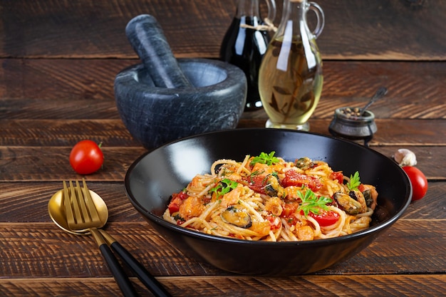 Foto pasta de frutos do mar com amêijoas, salmão e tomates, espaguete com coquetel de frutos do mar