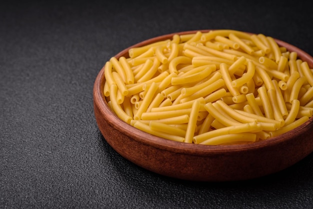 Pasta de trigo integral cru com sal e especiarias em um prato de cerâmica