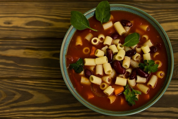 Pasta Ditalini en salsa de tomate, sobre un fondo de madera. Vista desde arriba