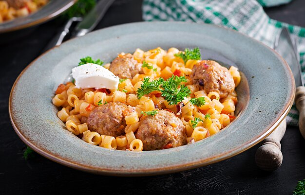 Pasta ditalini tradicional italiana con albóndigas en salsa de tomate y verduras en un tazón. Pasta ditalini y albóndigas de ternera con salsa de tomate marinara.