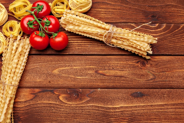 Pasta e ingredientes en madera con espacio de copia. Vista superior.