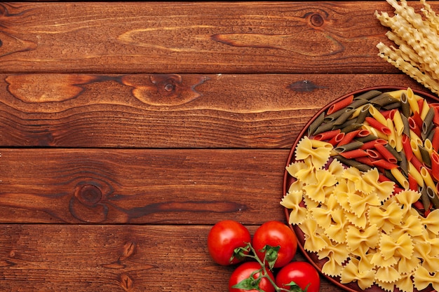 Pasta e ingredientes sobre fondo de madera con espacio de copia. Vista superior.