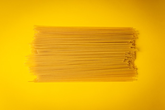 Pasta entera sobre fondo amarillo.