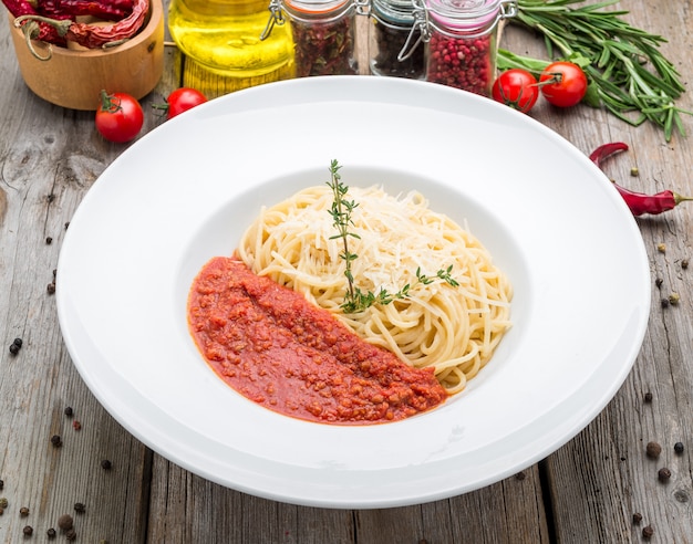 Pasta de espagueti con albóndigas, salsa de tomate, queso parmesano rallado y albahaca fresca