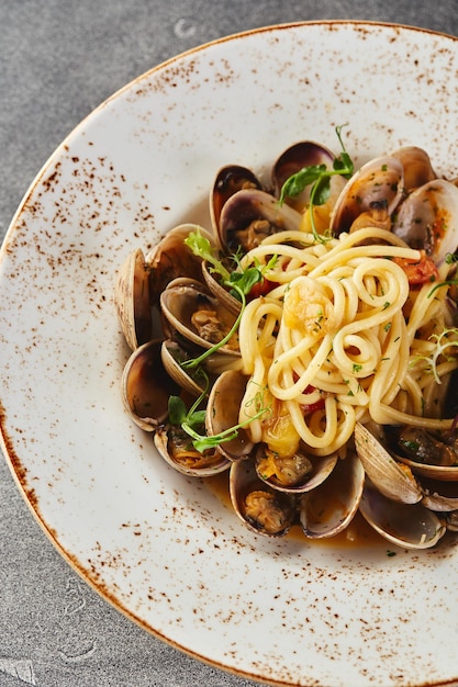 Pasta de espagueti alle vongole pasta de marisco con almejas en plato sobre fondo gris