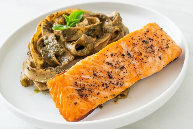 Pasta de espagueti fettuccine al pesto casero con filete de salmón a la parrilla