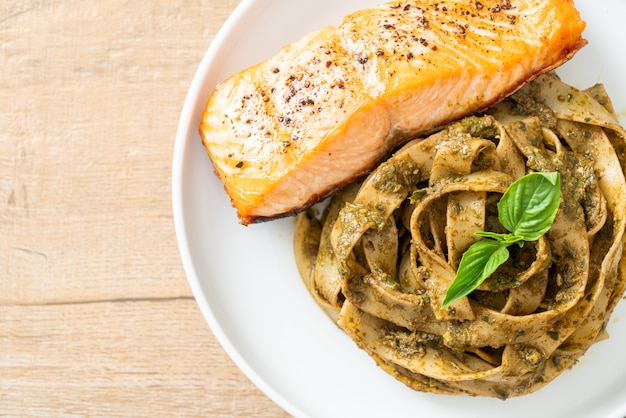 Pasta de espagueti fettuccine al pesto casero con filete de salmón a la parrilla