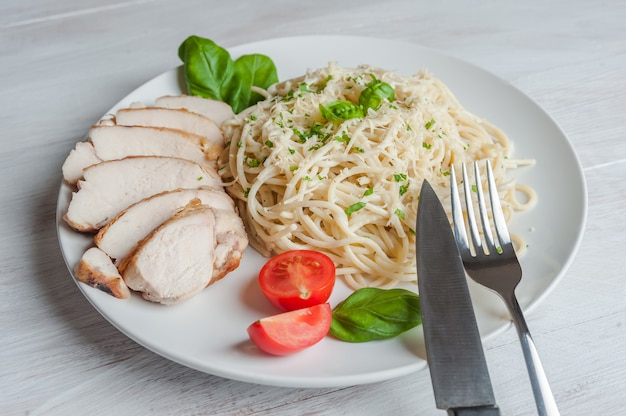 Pasta espagueti italiana con salsa y pollo, queso parmesano y albahaca