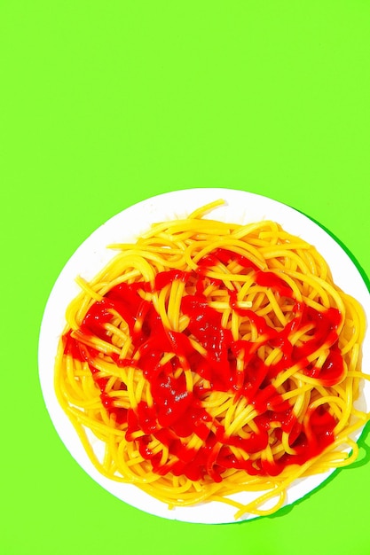 Pasta de espagueti con ketchup sobre fondo verde Concepto de arte de comida italiana de calorías de dieta minimalista