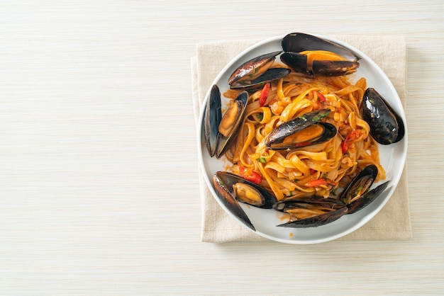 Pasta de espagueti con mejillones o almejas y salsa de tomate - Estilo de comida italiana