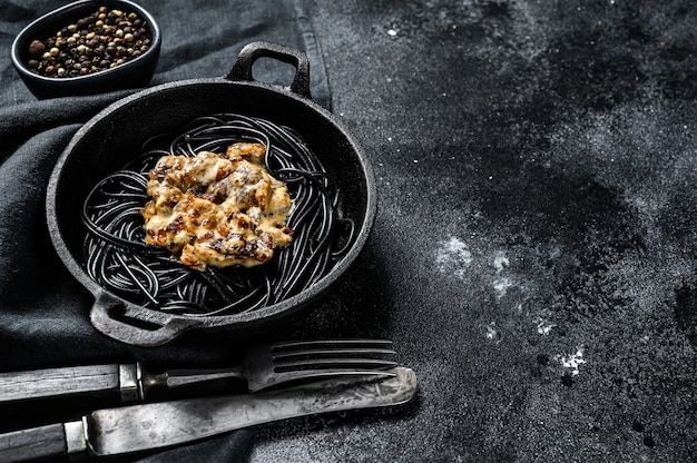 Pasta de espagueti negro con tinta de calamar en una sartén