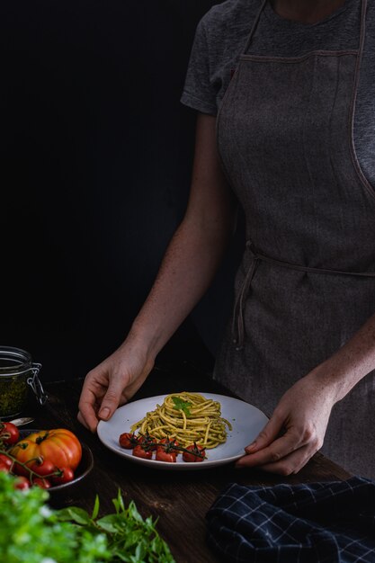 Pasta de espagueti con pesto de albahaca y tomates