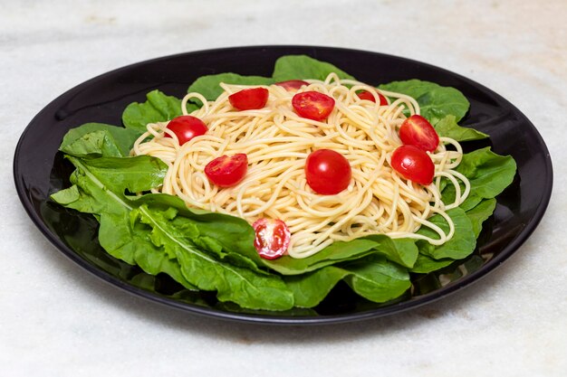 Pasta de espagueti con rúcula y tomates cherry