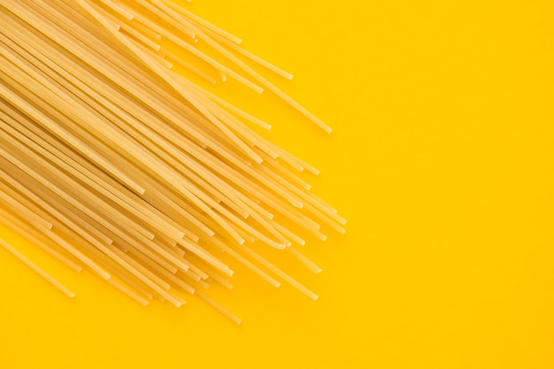 Foto pasta de espagueti sobre fondo amarillo desde arriba