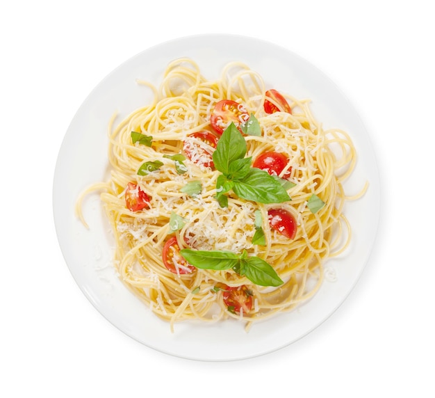 La pasta de espagueti con tomates y albahaca en la vista superior estaba aislada en blanco
