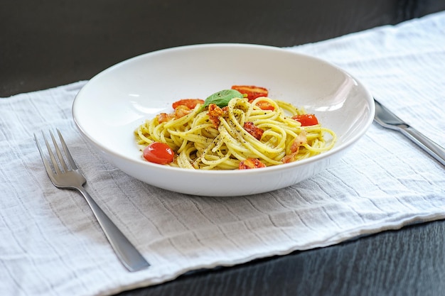 Pasta de espagueti con tomates cherry en un plato blanco