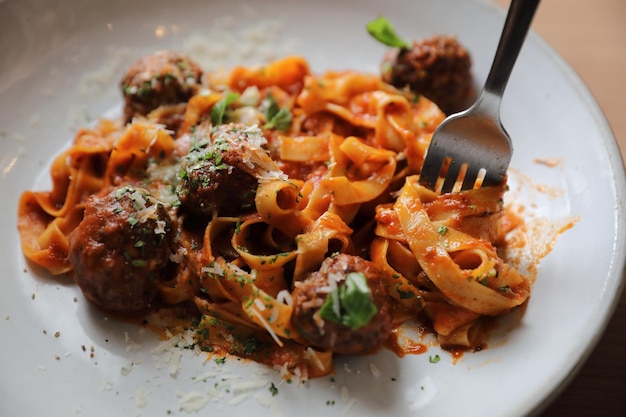 Pasta de espaguetis con albóndigas de ternera y salsa de tomate sobre fondo de madera. comida italiana